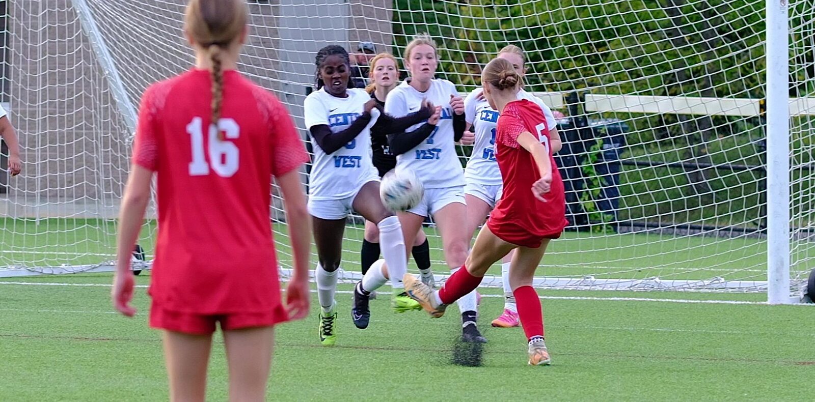 Central-West defenders converging to block a shot in front of goal