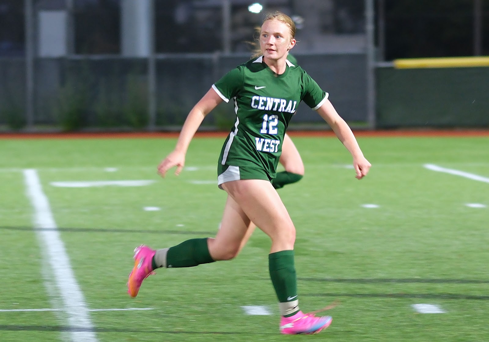 Central West girls' soccer players lined up arm in arm in front of the goal